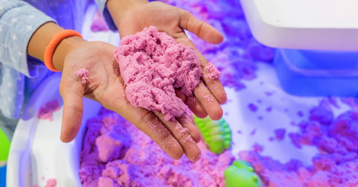 Barn med kinetic sand i hænderne